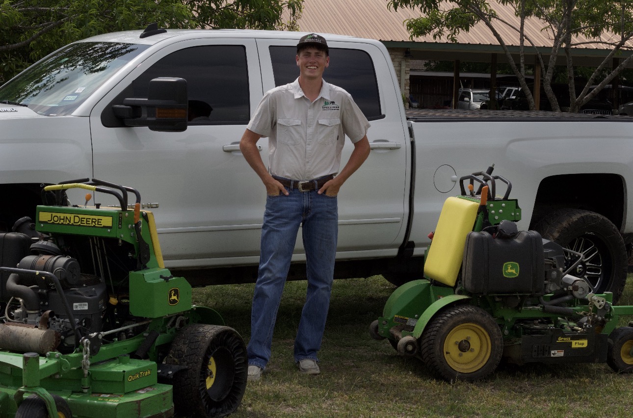 Levi Spelling, owner of Spellings Lawn & Outdoor Services, with his truck and John Deere mowers